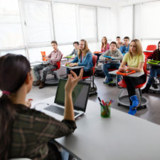 Group of K-12 students studying on their school-issued tablets