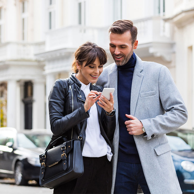 Photo of a man and a woman looking at the woman's phone together.