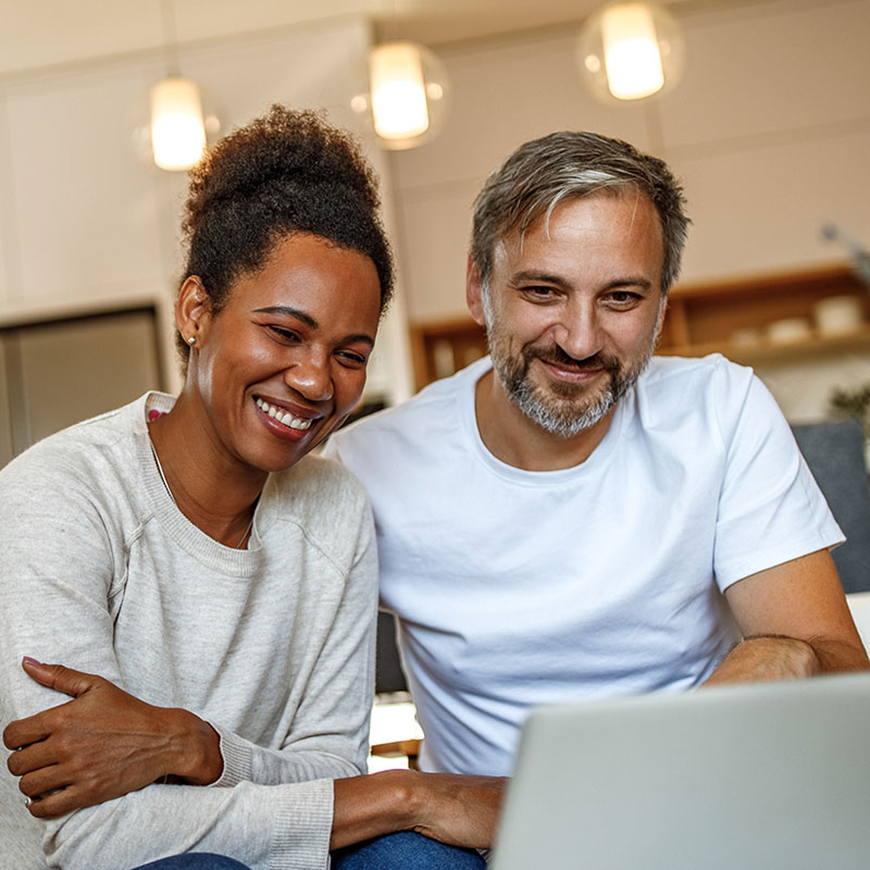 Cambium Networks provides great performance for rural wireless. Image of a man and woman sharing a laptop in their home.