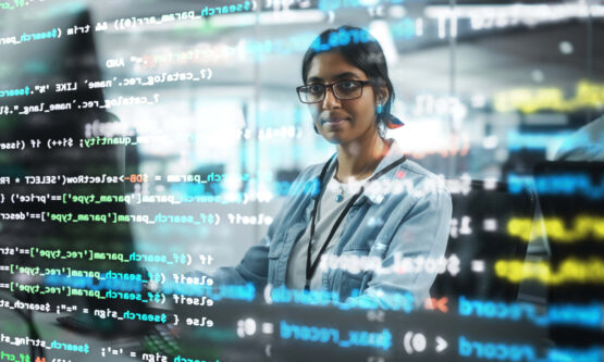 Diverse Office: Portrait of Confident Indian IT Programmer Working on Desktop Computer. Professional Female Specialist Develop Innovative Software. Shot with Visual Effects of Running Code.