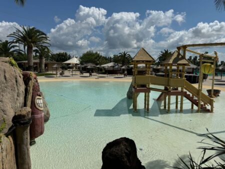 Area giochi per bambini nel parco acquatico Acqua Village di Follonica con scenografia tropicale e piscina a bassa profondità