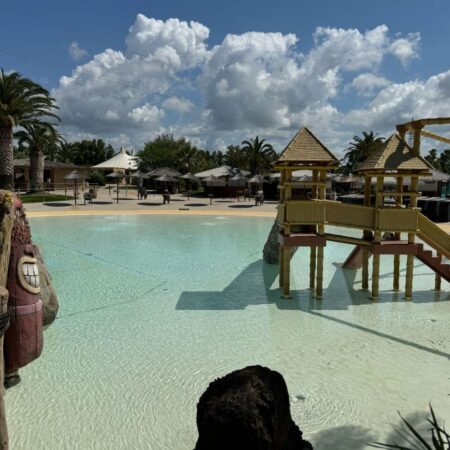 Area giochi per bambini nel parco acquatico Acqua Village di Follonica con scenografia tropicale e piscina a bassa profondità