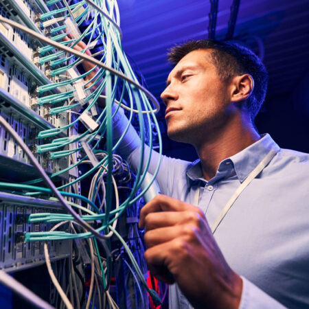 A man inspecting fiber solutions equipment.